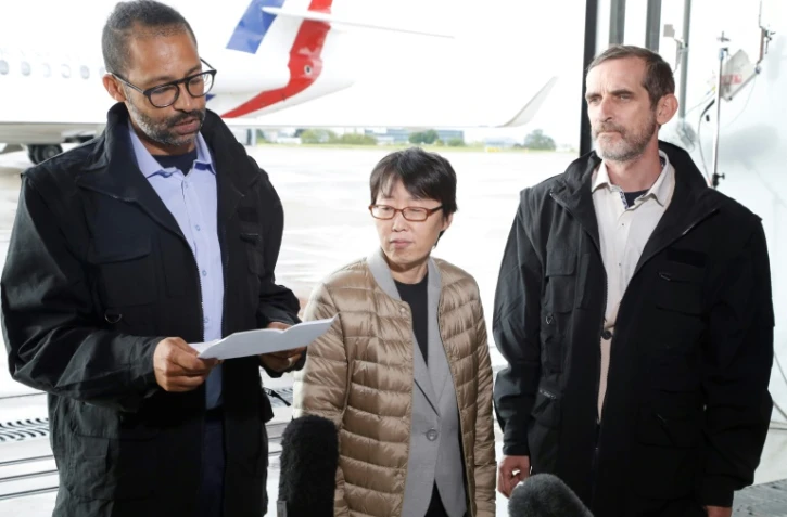 L'ex-otage Laurent Lassimouillas (G) lit sa déclaration à son arrivée à Villacoublay, en présence de Patrick Picque (D) et de l'ex-otage sud-coréenne, libérés avec lui l'avant-veille au Burkina