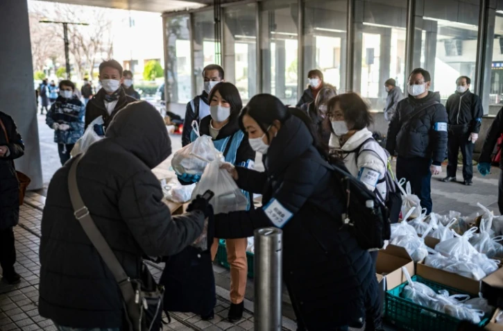 Des bénévoles de l'ONG Moyai distribuent des colis alimentaires à Tokyo, le 9 janvier 2021
