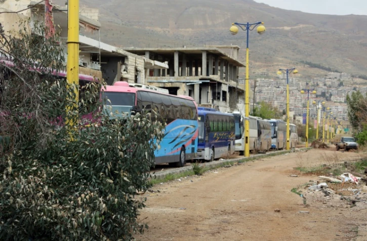 Un convoi de bus entre dans la ville rebelle de Zabadani, au nord-ouest de Damas, pour une opération d'évacuation de civils et combattants, le 12 avril 2017 en Syrie