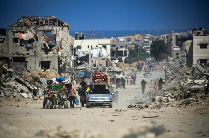 Des Palestiniens à pied et en voiture quittent Khan Younès, le sud de la bande de Gaza, au milieu des destructions, le 3 juillet 2024