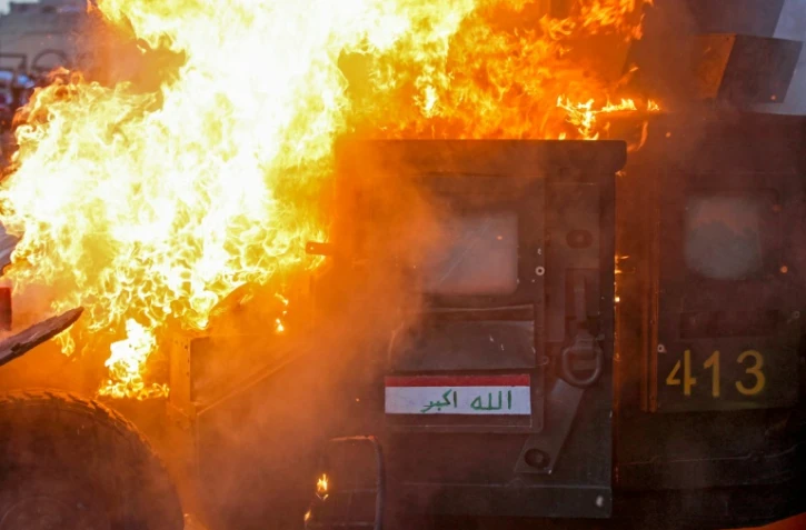 Un véhicule des forces anti-émeutes en feu lors d'affrontements entre forces de l'ordre et manifestants le 3 octobre sur la place Tahrir à Bagdad
