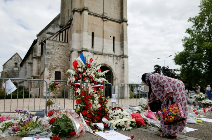 Une femme dépose des fleurs devant l'église de Saint-Étienne-du-Rouvray, le 29 juillet 2016