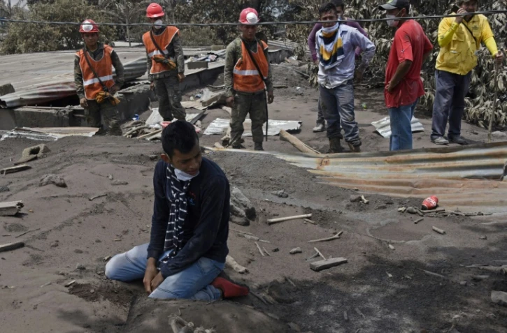 Un homme pleure devant sa maison ensevellie de cendres les membres de sa famille disparus, le 7 juin 2018 à Escuintla