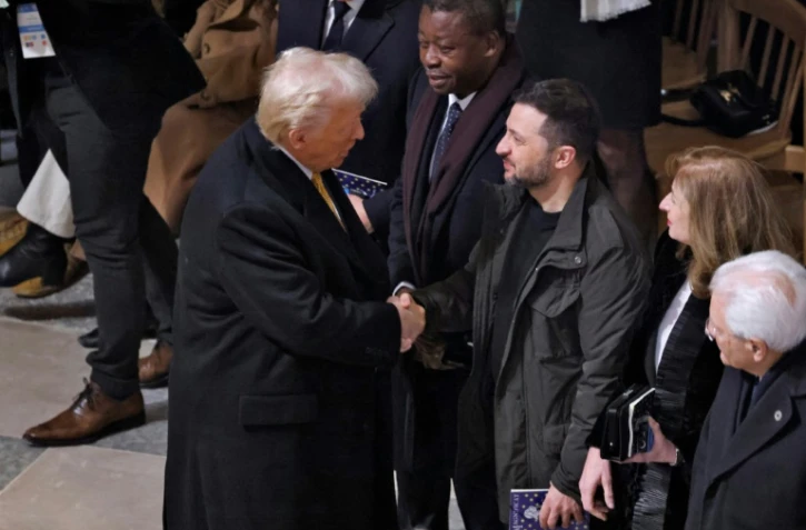 Le président américain élu Donald Trump (g) serre la main du président ukrainien Volodymyr Zelensky à l'intérieur de Notre-Dame de Paris, avant le début de la cérémonie marquant la réouverture officielle de la cathédrale, le 7 décembre 2024 à Paris