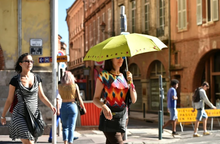 Une femme se protège du soleil pendant qu'elle se promène à Toulouse le 23 août 2016