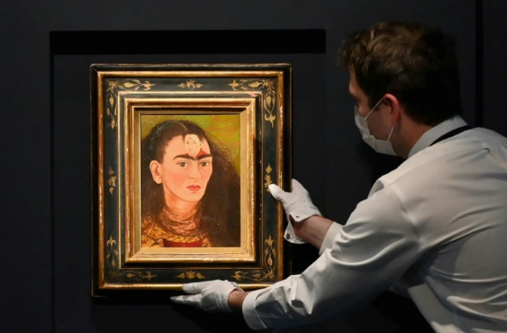 Un employé de Sotheby's ajuste un autoportrait de Frida Kahlo, "Diego y yo", le 5 novembre 2021, à New York