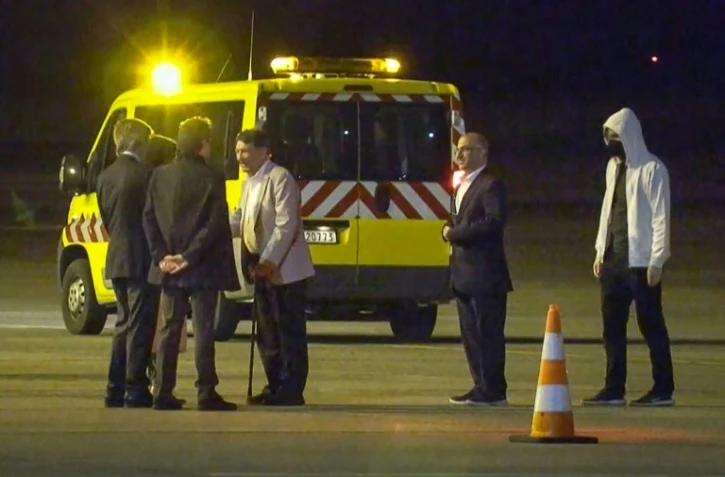 Les Irano-Autrichiens Kamran Ghaderi (2e à droite) et Massud Mossaheb (centre) ainsi qu'un citoyen danois (droite) reçus à l'aéroport militaire de Melsbroek, en Belgique, le 3 juin 2023 après leur libération d'Iran