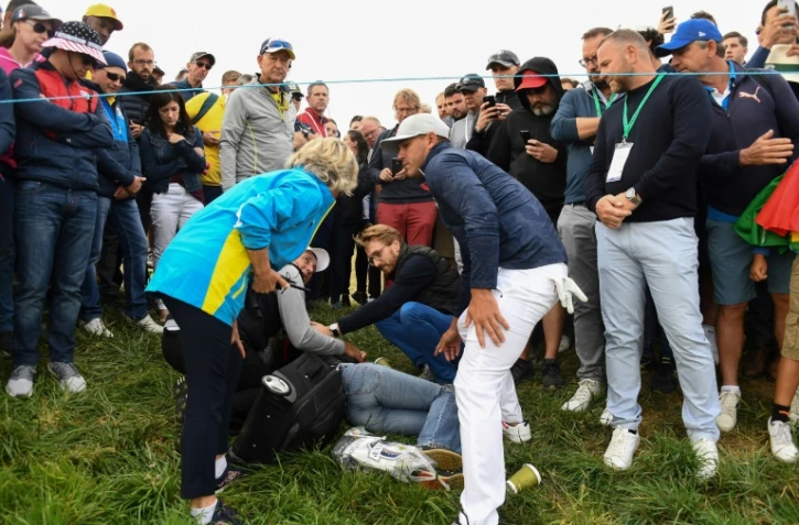 Une spectatrice blessée par une balle de golf, jouée par l'Américain Brooks Koepka (d), lors de la Ryder Cup le 28 septembre 2018 à Saint-Quentin-en-Yvelines