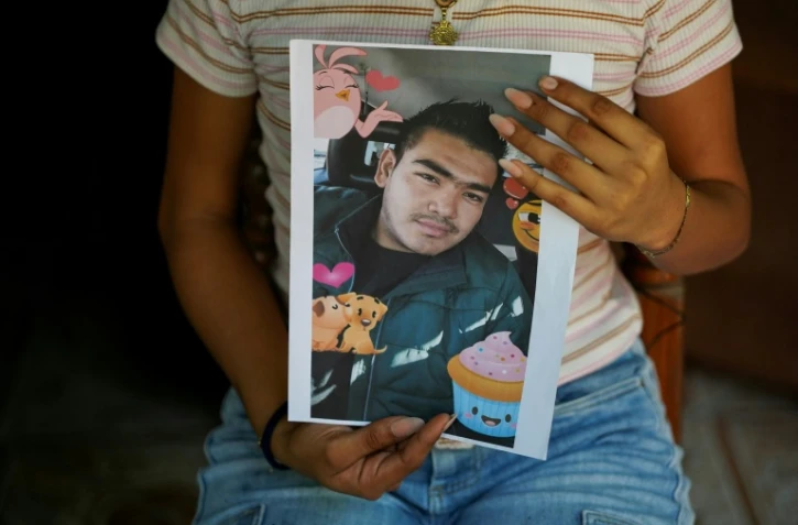 Jade, 16 ans, tient dans ses mains le portrait de son père Jose Roger Urquilla, le 3 décembre 2025 à El Rosario, au Salvador.