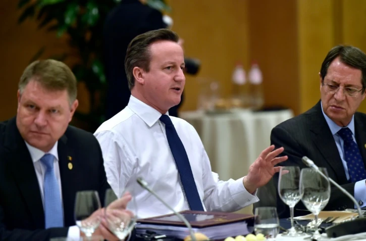 Le premier ministre britannique David Cameron (c) entre les présidents roumain Klaus Werner Iohannis (g) et chypriote Nicos Anastasiades (d) lors d'un dîner des dirigeants européens à Bruxelles le 19 février 2016