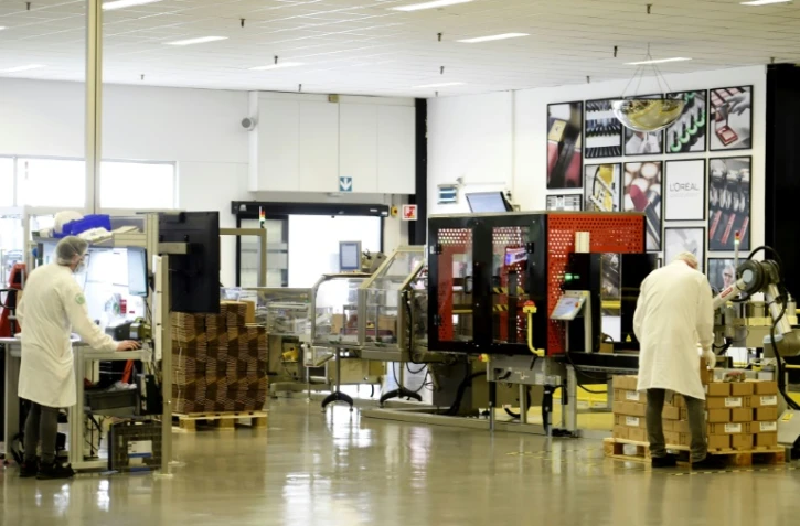 Des employés de l'usine de maquillage de luxe de L'Oréal vérifient les produits, le 6 octobre 2021 à Lassigny, dans l'Oise