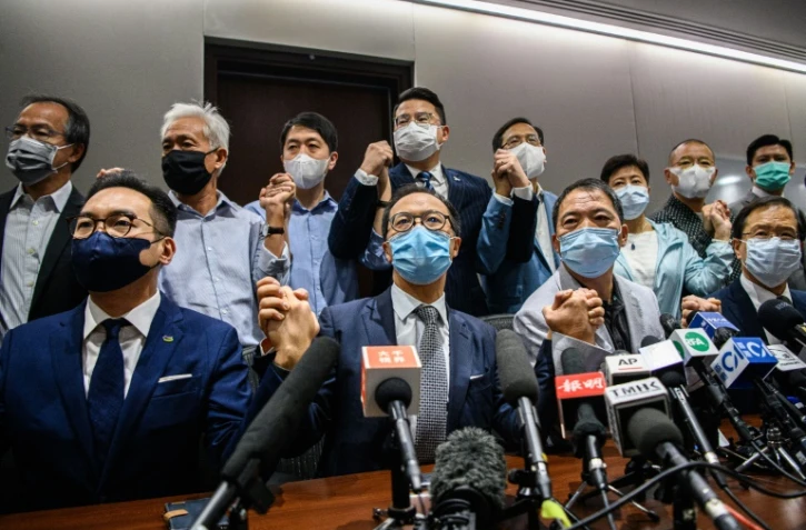 Des députés pro-démocratie se tiennent par la main au début d'une conférence de presse à Hong Kong le 11 novembre 2020