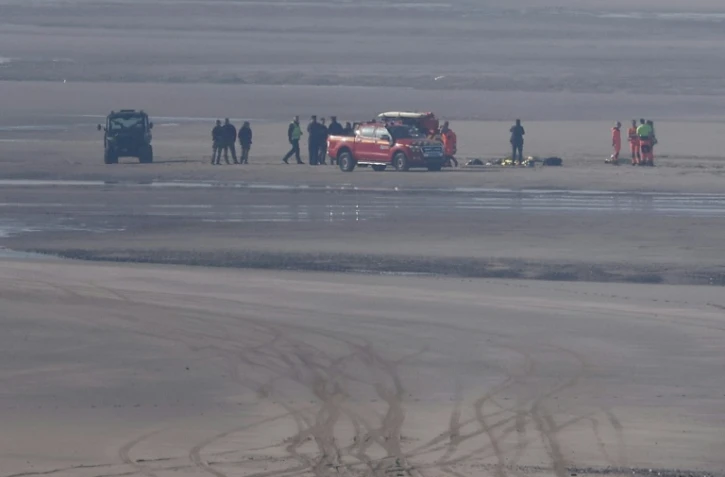 Des véhicules de secours et des unités médicales sur la plage pour soigner des migrants après qu'une tentative de traversée illégale de la Manche a tourné au drame, le 9 avril 2026 à Equihen-Plage, dans le Pas-de-Calais