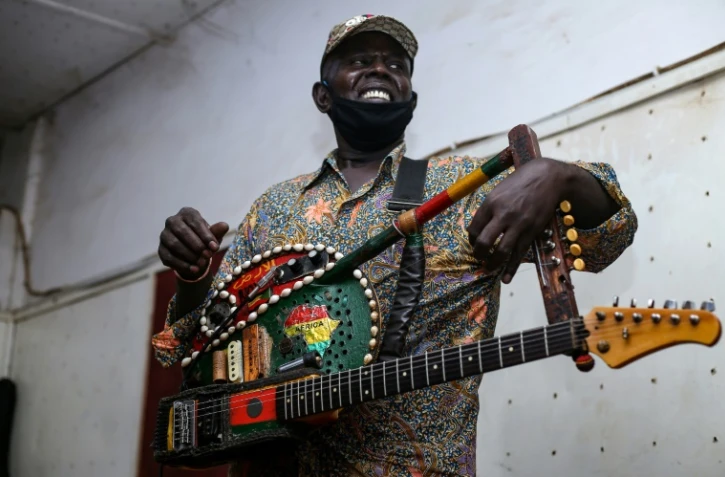 Le musicien soudanais Noureddine Jaber joue du "tambo-guitare" le 18 mai 2022 lors d'enregistrements dans un studio d'Omdurman, la ville jumelle de Khartoum