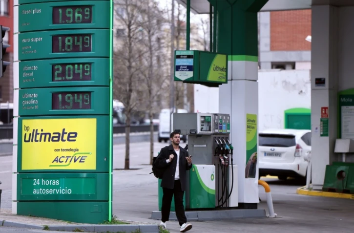 Un homme marche devant une station service à Madrid le 20 mars 2026