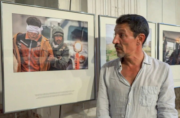 Le photographe français Frédéric Lafargue pose devant sa série de photos intitulée "Echapper à Daech", le 1er septembre 2016 à Perpignan