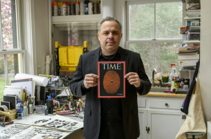 L'artiste américano-cubain Edel Rodriguez pose dans son studio avec sa dernière illustration à l'occasion de l'inculpation de Donald Trump, le 7 avril 2023 à Tabor, dans le New Jersey