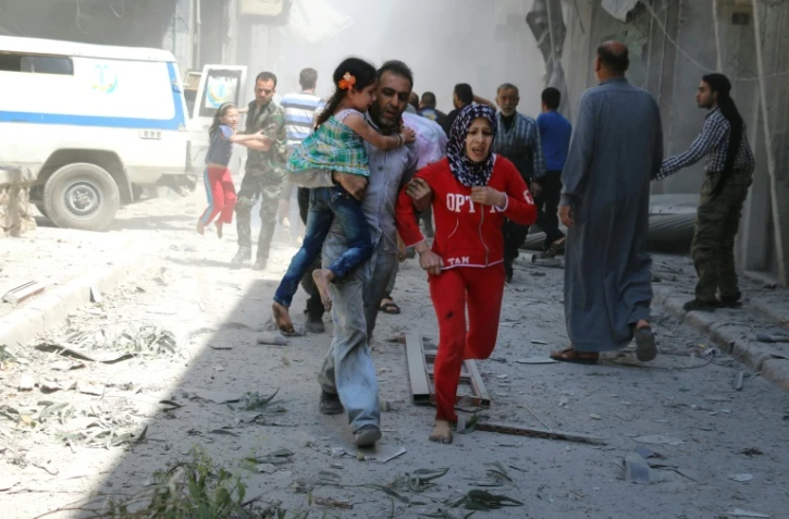 Des civils fuient les bombardements le 29 avril 2016 à Alep
