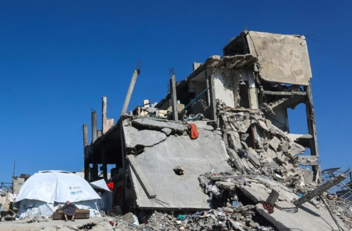 Un Palestinien devant sa tente, à côté des ruines d'un immeuble à Jabalia, dans le nord de la bande de Gaza, le 27 février 2025