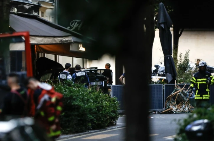 Des policiers près du lieu où un automobiliste a foncé sur la terrasse d'un café, le 17 juillet 2024 à Paris