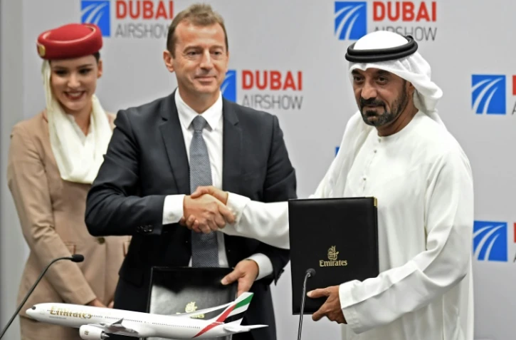 Le président de la compagnie Emirates, cheikh Ahmed ben Saïd Al-Maktoum (R), et le président d'Airbus, Guillaume Faury, se serrent la main après la signature d'un contrat au Dubaï Airshow le 18 novembre