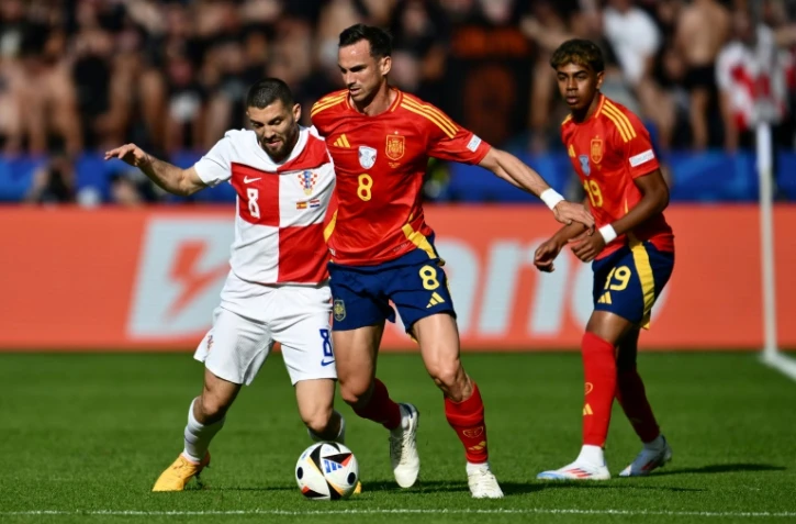Les Espagnols Fabian Ruiz (c) et Lamine Yamal (d) avec le Croate Mateo Kovacic lors du premier match du groupe B de l'Euro, le 15 juin 2024 Ă Berlin