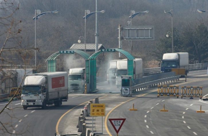 Des véhicules quittant la zone industrielle intercoréenne de Kaesong passent un barrage routier à Paju près de la zone démilitarisée séparant les Corées du Nord et du Sud le 11 février 2016