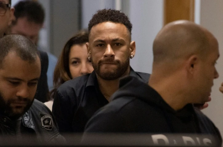 L'attaquant vedette Neymar (c) quitte le poste de police de Rio de Janeiro le 6 juin 2019, où il a été auditionné pour avoir divulgué sur internet ses échanges avec Najila Trindade, qui l'accuse de viol