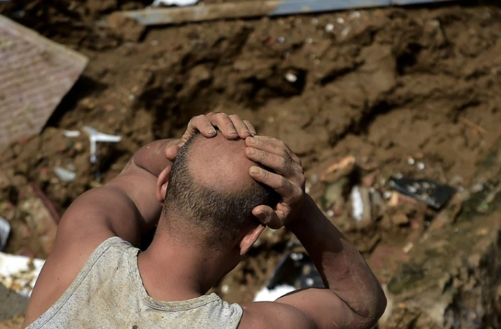Un homme réagit devant les dégâts laissés par un glissement de terrain à Petropolis (sud-est du Brésil), le 16 février 2022