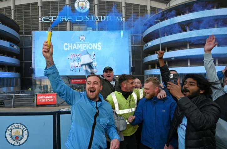 Les supporters de Manchester City en liesse devant leur stade après le sacre de champion de leur équipe consécutif à la défaite de Mnchester United, le 11 mai 2021