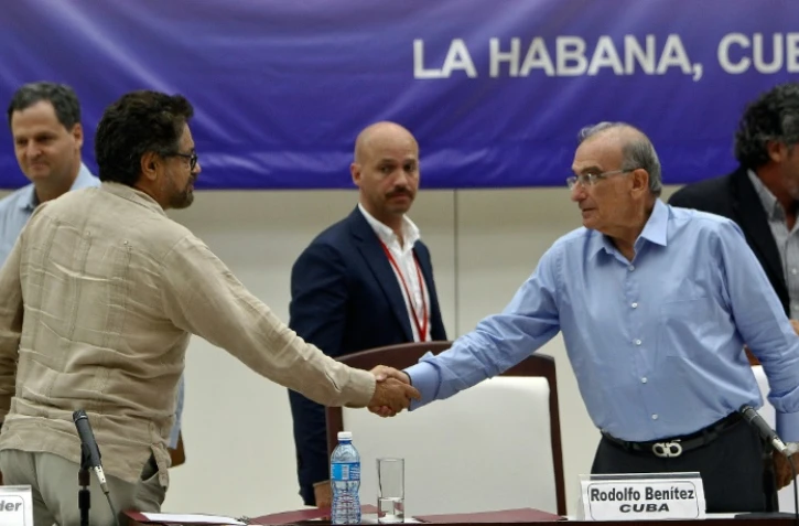Ivan Marquez, négociateur pour les FARC (G) serre la main à Humberto de la Calle (D), chef de la délégation gouvernementale, à La Havane (Cuba), le 5 août 2016