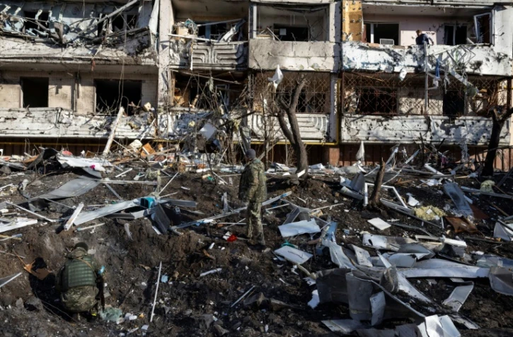 Des soldats ukrainiens dans les décombres d'un immeuble touché par une frappe, à Kiev le 15 mars 2022