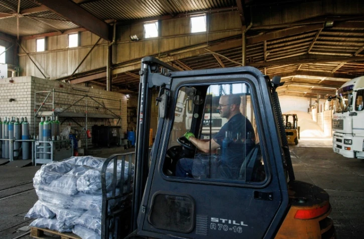 Le fournisseur Frithjof Engelke transporte sur un chariot élévateur des sacs de charbon dans un hangar de stockage de l'entreprise familiale Hans Engelke Energie, le 10 août 2022 à Berlin