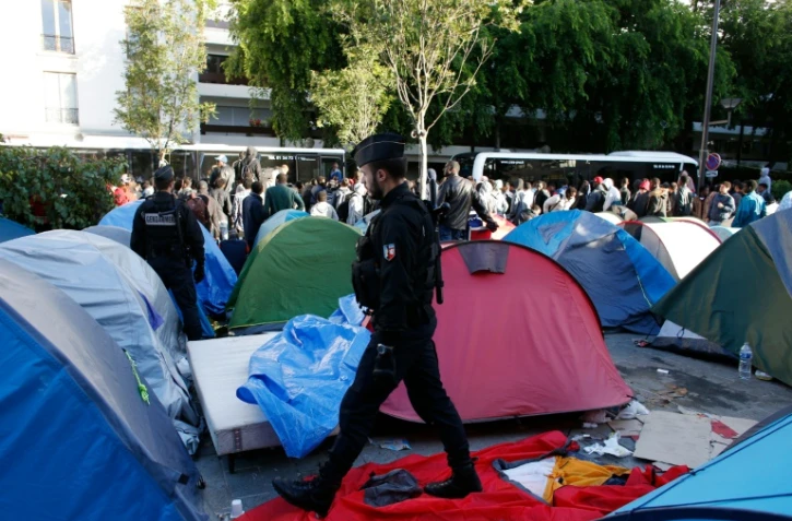 Des gendarmes mènent l'évacuation d'un campement de migrants à la hall Pajol, le 29 juin 2016 à Paris