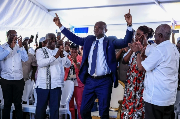 Le président élu du Gabon Brice Clotaire Oligui Nguema (Centre) lève les doigts au ciel, le 13 avril 2025 à Libreville, lors de l'annonce des résultats de l'élection présidentielle qui a mis fin à 19 mois de transition dans le pays