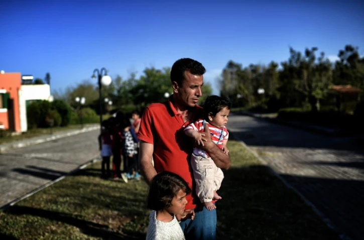 Un réfugié syrien et ses enfatns le 20 avril 2016 à Myrsini en Grèce