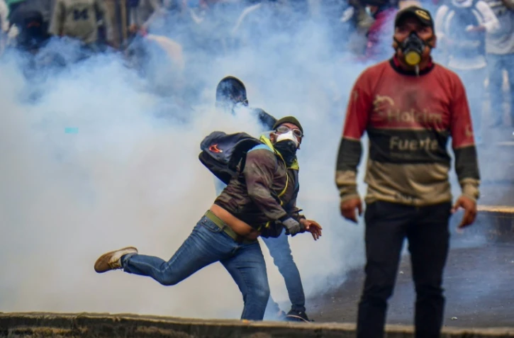 Un manifestant renvoie une cartouche de gaz lacrymogène pendant une manifestation à Quito, en Equateur, le 11 octobre 2019