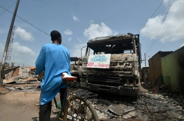 Une pancarte appelant à l'arrêt des violences sur un camion calciné sur le marché de Toumodi, le 4 novembre 2020 en Côte d'Ivoire