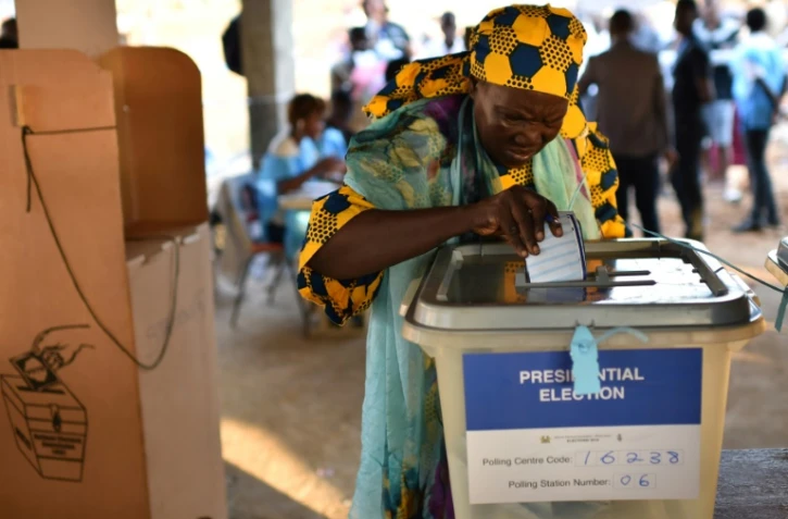 Une femme glisse son bulletin dans l'urne lors des élections générales au Sierra Leone, le 7 mars 2018 à Freetown