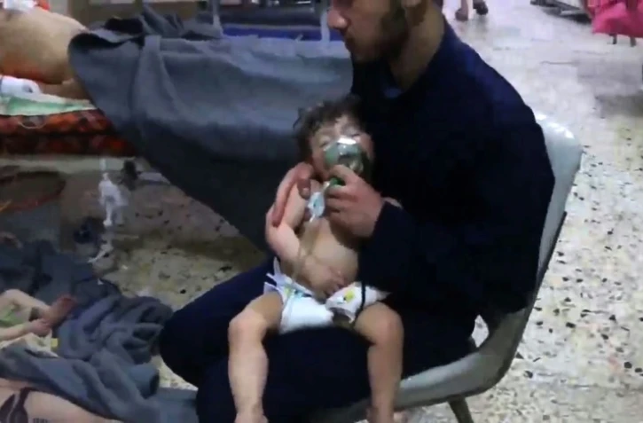 Une image capturée sur une vidéo diffusée par les secouristes syriens en zones rebelles, les Casques blancs, montrant un enfant victime d'une attaque chimique présumée soigné dans un hôpital improvisé de Douma le 8 avril 2018