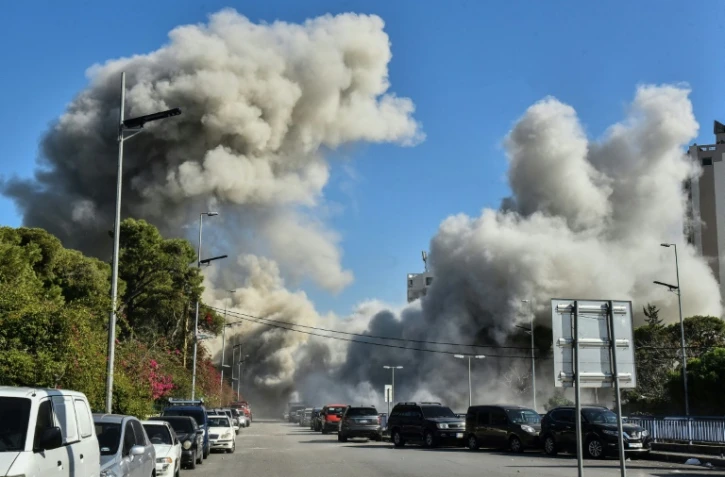 De la fumée s'élève d'une rue après un bombardement israélien sur un bâtiment du secteur de Ghobeiri, dans la banlieue sud de Beyrouth, le 15 novembre 2024, sur fond de conflit entre Israël et le Hezbollah libanais