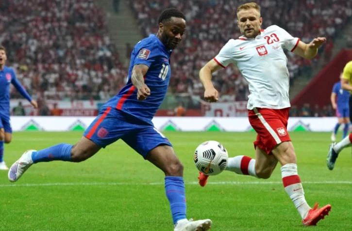 L'attaquant anglais Raheem Sterling, aux prises avec le défenseur polonais Tymoteusz Puchacz, lors des qualifications européennes pour le Mondial-2022 au Qatar, le 8 septembre 2021 à Varsovie