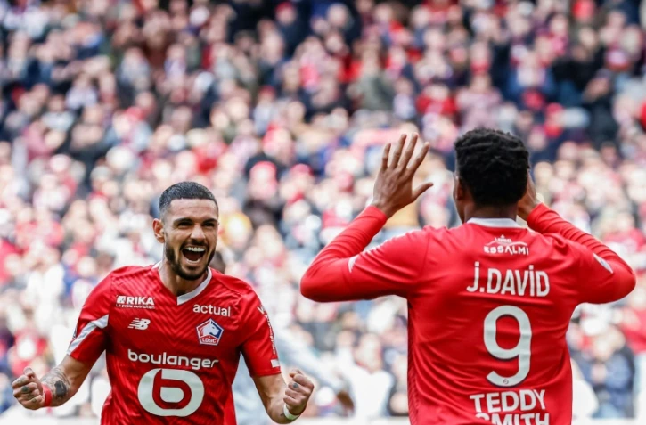 Le Canadien du Lille Jonathan David (de dos), buteur contre Strasbourg, remercie son passeur Rémy Cabella, le 21 avril 2024 à Villeneuve-d'Ascq