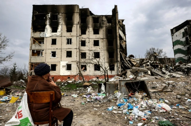 Antonina Kaletnyk devant un immeuble détruit par les bombardements russes, le 8 avril 2022 au nord-ouest de Kiev, en Ukraine