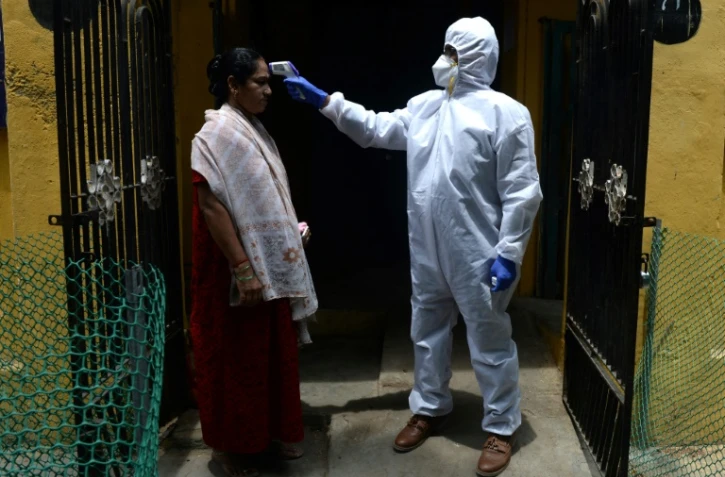 Contrôle de la température d'une habitante le 29 juin 2020 à Chennai, dans le sud de l'Inde, qui a été reconfinée le 19 juin