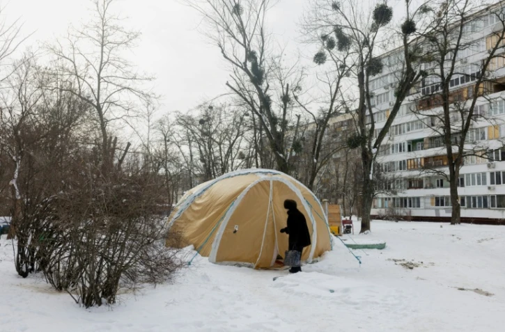 Une femme entre dans une tente proposant des services d'urgence, installée pour les personnes dont les logements sont privés d'électricité ou de chauffage, à Kiev, le 18 février 2026