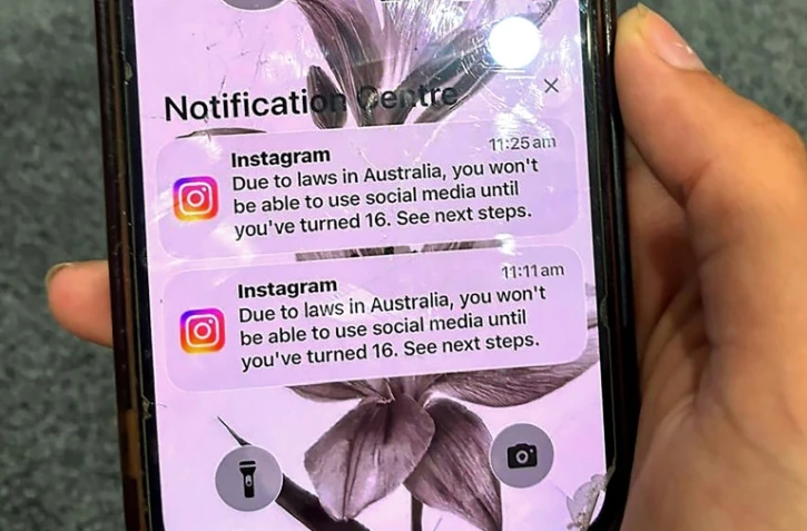 Un adolescent tient un téléphone portable affichant un message du réseau social Instagram après que son compte a été verrouillé en raison de son âge, à Sydney, le 9 décembre 2025