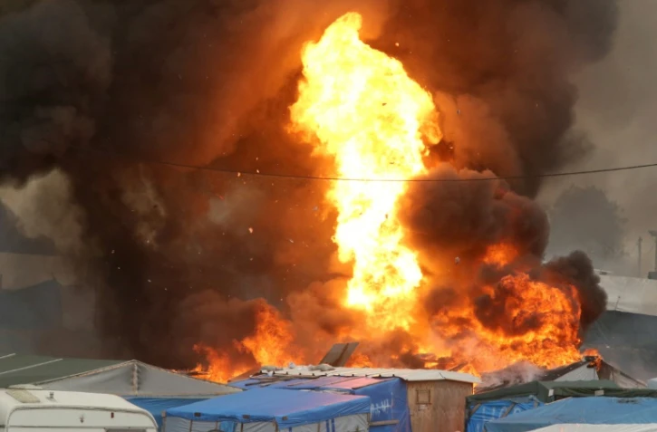 Des flammes dans le bidonville géant de Calais (nord), le 26 octobre 2016, avant la fin de son évacuation.