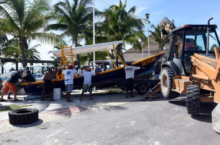 Des pêcheurs et employés mettent à l'abri des bateau avant l'arrivée de l'ouragan Delta, le 6 octobre 2020 à Puerto Morelos, au Mexique