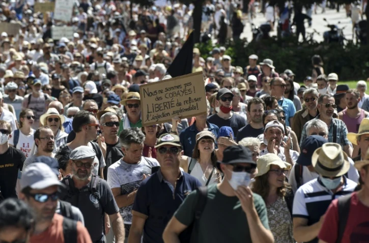 Un manifestant tient une pancarte lors d'une journée nationale de protestation contre le vaccin obligatoire pour certains travailleurs, et le pass santé demandé par le gouvernement français, à Nantes, le 14 août 2021
